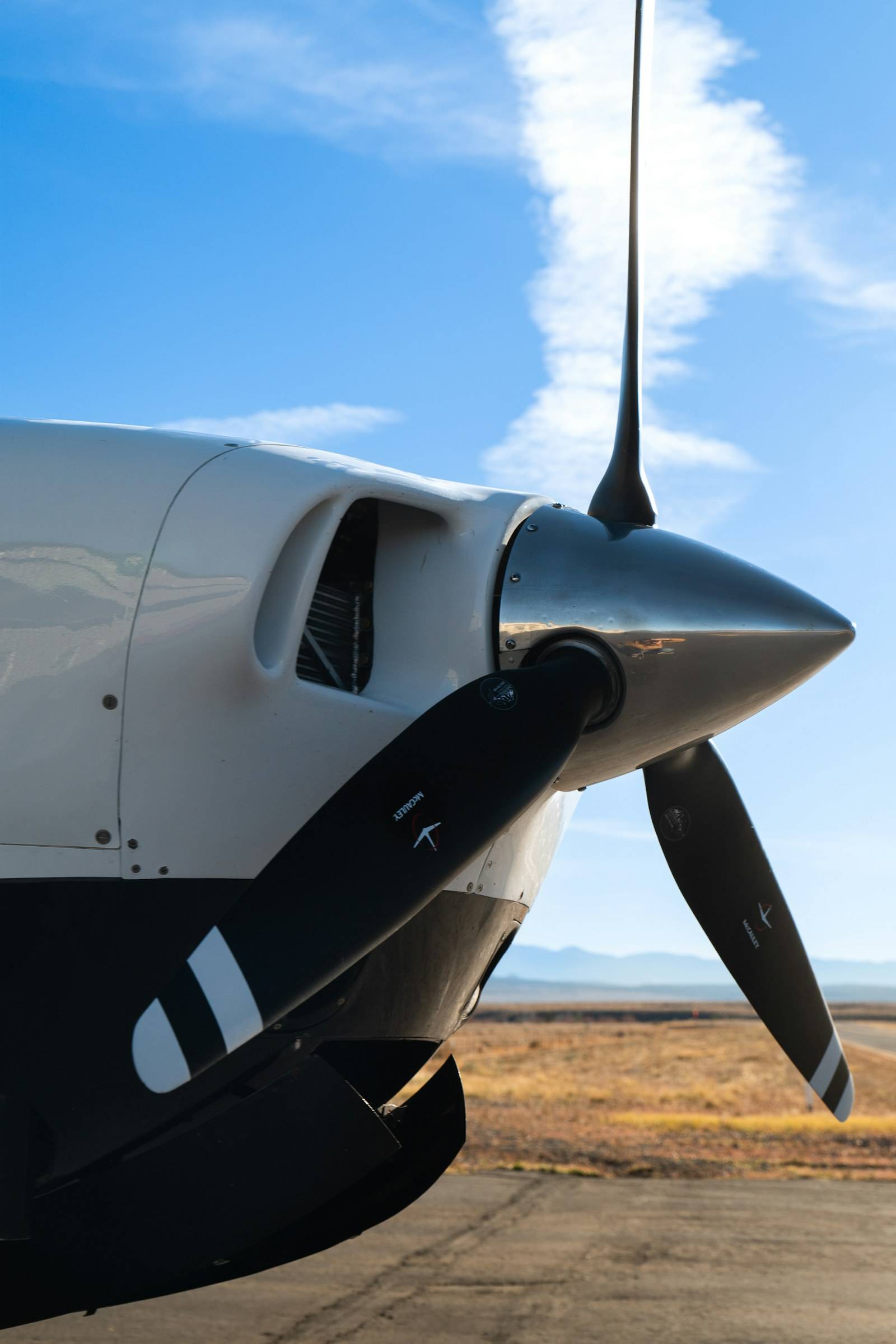 Close-up of a turboprop engine and propeller against a clear blue sky
