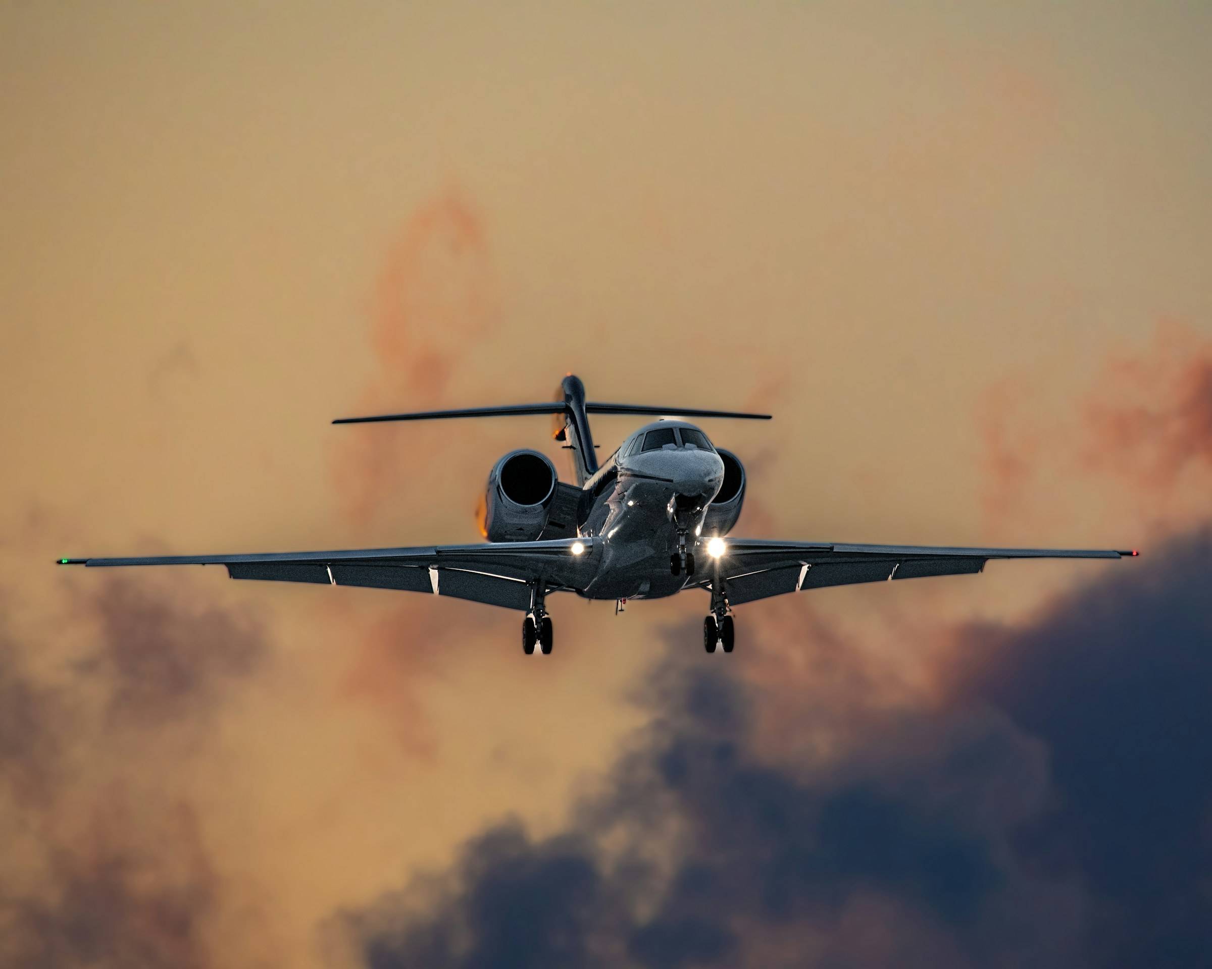 A business jet climbing through warm evening cloud